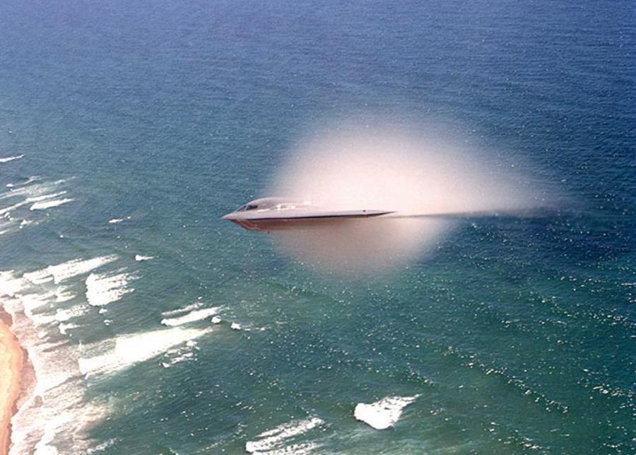 7. A B-2 Spirit Stealth Bomber, United States Air Force, Pacific Ocean. Reaching the sound barrier, breaking the sound barrier: Flying at transonic speeds (flying transonically) -- speeds varying near and at the speed of sound (supersonic) -- can generate impressive condensation clouds caused by the Prandtl-Glauert Singularity. For a scientific explanation, see Professor M. S. Cramer's Gallery of Fluid Mechanics, Prandtl-Glauert Singularity at <http://www.GalleryOfFluidMechanics.com/conden/pg_sing.htm>; and Foundations of Fluid Mechanics, Navier-Stokes Equations Potential Flows: Prandtl-Glauert Similarity Laws at <http://www.Navier-Stokes.net/nspfsim.htm>. Photo Credit: Bobbi Garcia, News - Archive (http://www.edwards.af.mil/archive, January 10, 2003, Edwards photographer awarded first place in photo contest), Air Force Flight Test Center, Edwards Air Force Base (http://www.edwards.af.mil), United States Air Force (USAF, http://www.af.mil), United States Department of Defense (DoD, http://www.DefenseLink.mil or http://www.dod.gov), Government of the United States of America (USA).