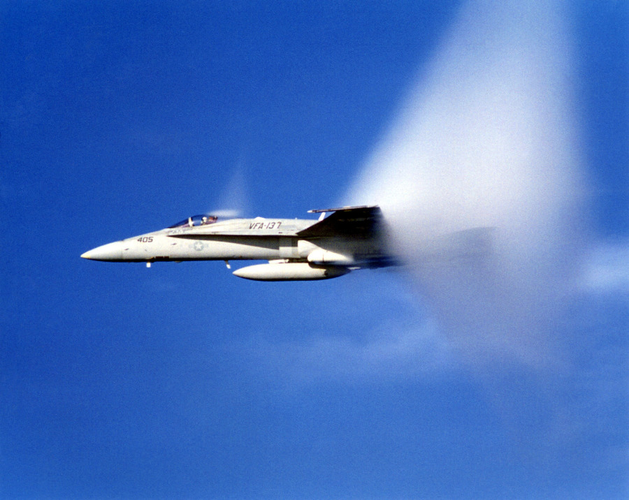 8. An F-18 Hornet From Strike Fighter Squadron 137 (VFA-137), United States Navy, Off the Coast of San Diego, California, USA, Pacific Ocean. Reaching the sound barrier, breaking the sound barrier: Flying at transonic speeds (flying transonically) -- speeds varying near and at the speed of sound (supersonic) -- can generate impressive condensation clouds caused by the Prandtl-Glauert Singularity. For a scientific explanation, see Professor M. S. Cramer's Gallery of Fluid Mechanics, Prandtl-Glauert Singularity at <http://www.GalleryOfFluidMechanics.com/conden/pg_sing.htm>; and Foundations of Fluid Mechanics, Navier-Stokes Equations Potential Flows: Prandtl-Glauert Similarity Laws at <http://www.Navier-Stokes.net/nspfsim.htm>. Photo Credit: Defense Visual Information Center (DVIC, http://www.DoDMedia.osd.mil, DNSD9905858) and United States Navy (USN, http://www.navy.mil), United States Department of Defense (DoD, http://www.DefenseLink.mil or http://www.dod.gov), Government of the United States of America (USA).