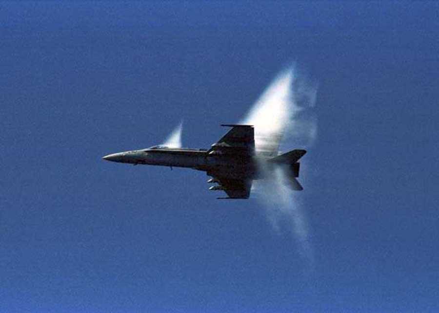 7. An F/A-18 Hornet Fighter Jet, United States Navy, Off the Coast of Japan, Sea of Japan. Reaching the sound barrier, breaking the sound barrier: Flying at transonic speeds (flying transonically) -- speeds varying near and at the speed of sound (supersonic) -- can generate impressive condensation clouds caused by the Prandtl-Glauert Singularity. For a scientific explanation, see Professor M. S. Cramer's Gallery of Fluid Mechanics, Prandtl-Glauert Singularity at <http://www.GalleryOfFluidMechanics.com/conden/pg_sing.htm>; and Foundations of Fluid Mechanics, Navier-Stokes Equations Potential Flows: Prandtl-Glauert Similarity Laws at <http://www.Navier-Stokes.net/nspfsim.htm>. Photo Credit: Seventh Fleet - Photos (http://www.c7f.navy.mil/images.html, November 12, Sea of Japan), Commander, U.S. Seventh Fleet (http://www.c7f.navy.mil), United States Navy (USN, http://www.navy.mil), United States Department of Defense (DoD, http://www.DefenseLink.mil or http://www.dod.gov), Government of the United States of America (USA).