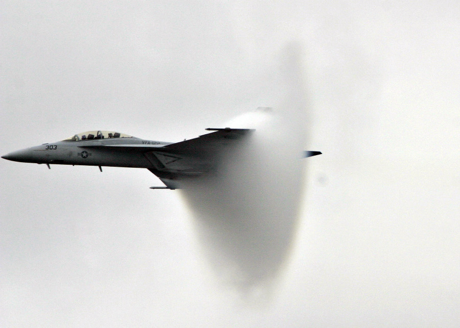 9. An F/A-18F Super Hornet Fighter Jet, November 13, 2004, United States Navy. Pensacola, State of Florida, USA. Reaching the sound barrier, breaking the sound barrier: Flying at transonic speeds (flying transonically) -- speeds varying near and at the speed of sound (supersonic) -- can generate impressive condensation clouds caused by the Prandtl-Glauert Singularity. For a scientific explanation, see Professor M. S. Cramer's Gallery of Fluid Mechanics, Prandtl-Glauert Singularity at <http://www.GalleryOfFluidMechanics.com/conden/pg_sing.htm>; and Foundations of Fluid Mechanics, Navier-Stokes Equations Potential Flows: Prandtl-Glauert Similarity Laws at <http://www.Navier-Stokes.net/nspfsim.htm>. Photo Credit: Photographer's Mate 2nd Class Mark A. Ebert, Navy NewsStand - Eye on the Fleet Photo Gallery (http://www.news.navy.mil/view_photos.asp, 041113-N-4204E-512), United States Navy (USN, http://www.navy.mil), United States Department of Defense (DoD, http://www.DefenseLink.mil or http://www.dod.gov), Government of the United States of America (USA).