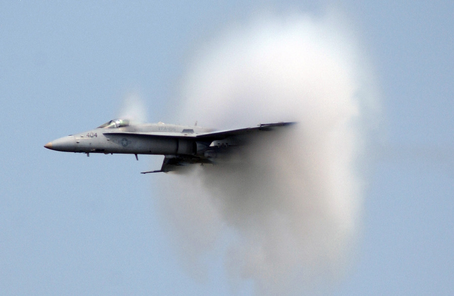 8. A United States Marine Corps F/A-18C Hornet Fighter Jet Assigned to the Strike Fighter Squadron One Nine Five (VFA-195) at Naval Air Station Atsugi (Japan), Freedom Through Friendship Air Show at Osan Air Base, September 10, 2005, Kyonggi-Do Province, Taehan-min'guk - Republic of Korea. Flying at transonic speeds (flying transonically) -- speeds varying near and at the speed of sound (supersonic) -- can generate impressive condensation clouds caused by the Prandtl-Glauert Singularity. For a scientific explanation, see Professor M. S. Cramer's Gallery of Fluid Mechanics, Prandtl-Glauert Singularity at <http://www.GalleryOfFluidMechanics.com/conden/pg_sing.htm>; and Foundations of Fluid Mechanics, Navier-Stokes Equations Potential Flows: Prandtl-Glauert Similarity Laws at <http://www.Navier-Stokes.net/nspfsim.htm>. Photo Credit: Tech. Sgt. Raheem Moore, United States Air Force (USAF, http://www.af.mil); Defense Visual Information Center (DVIC, http://www.DoDMedia.osd.mil, DFSD0602979 and 050910F4707M142) and United States Marine Corps (USMC, http://www.usmc.mil), United States Department of Defense (DoD, http://www.DefenseLink.mil or http://www.dod.gov), Government of the United States of America (USA).